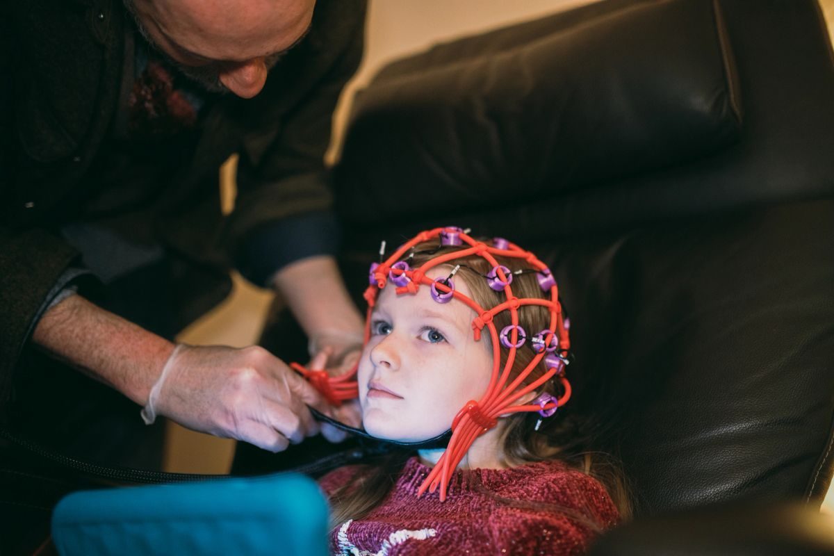 Clinician fitting an EEG cap for a neurofeedback session